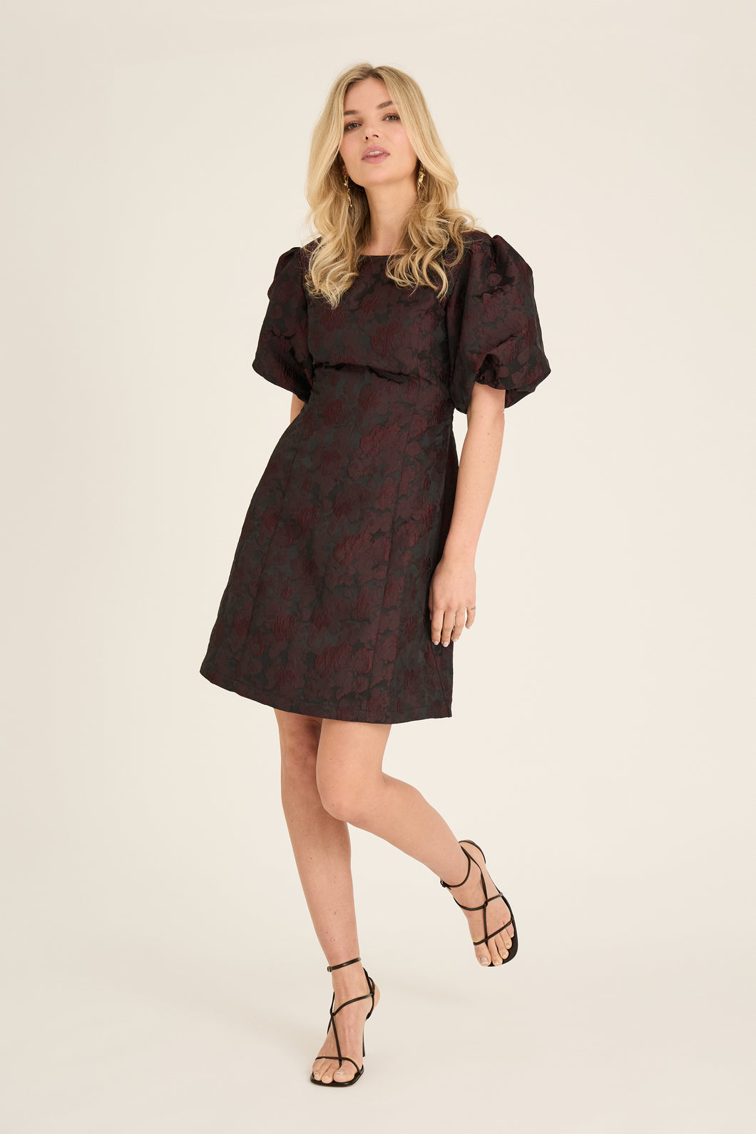 The Aria dress is a mini dress in a structured jacquard material. The dress is tight-fitting and has short puff sleeves. The dress has a round neckline and a nice neckline at the back that closes with buttons and a zipper.

The dress is true to size

 Jacquard material
 Fine necklines
 Puff sleeves
