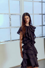 Load image into Gallery viewer, CMTILLY-DRESS is a flowing woven dress in a soft woven lyocell-blend fabric. Layered ruffles throughout the body for a voluminous, feminine expression. The silhouette is regular with an O-neck and short sleeves, finished with an asymmetric hem that moves elegantly

Soft woven lyocell-blend
Regular fit with O-neck and short sleeves
Exaggerated layered ruffle design with raw edges
Asymmetric hem for a fluid silhouette
Side seam at longest in size small is 68 cm. All measurements are indicative and may vary


