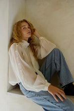 Load image into Gallery viewer, CMTILLY-BLOUSE is an extravagant blouse in a premium material with long voluminous balloon sleeves embellished with fabric buttons. In addition, the blouse has a round neckline with a removable scarf for an elegant cloak effect.


Long voluminous balloon sleeves
Embellished with fabric buttons
Rounded neckline
Removable scarf
Elegant cloak effect