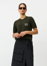 Load image into Gallery viewer, Short sleeve blouse
Looser fit
Monogram with glitter on chest
Ribbed cuffs at collar, bottom and sleeves
Merino wool and cashmere

Material:
It is knitted in a soft blend of 70% merino wool and 30% cashmere, which feels light and comfortable against the skin.