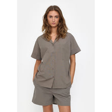 Load image into Gallery viewer, Oversized resort shirt made in 100% organic cotton.
GOTS certified

Crafted with classic short sleeves, dropped shoulders, and a front placket with buttons.
Chest pocket and a curved hem.

Perfect to wear as a relaxing shirt at home or outside tucked in a skirt or paired with jeans.

The full length is 70 cm in size S

- GOTS Certified
- Short sleeves
- Button closure
- Dropped shoulders
- The full length is 70 cm in size S

Composition: 100% Cotton - Organic