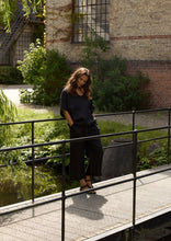 Load image into Gallery viewer, Hemp pants with a light and relaxed expression, shaped with flared legs and a mid-calf length. Designed with practical side pockets and finished with ties at the front for an easy, adjustable fit.

- 100% EU production
- 100% pure natural hemp
- OEKO-TEX® STANDARD 100 cert. no. 2176-347 DTI