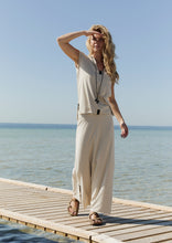 Load image into Gallery viewer, A sleeveless top with an elegant expression, designed with a V-neck and a refined collar detail. The straight fit and slightly longer back create a clean, flattering silhouette.
The style is finished with our signature handmade necklace, featuring the letter H on a 100% cotton string.

- 100% EU production 
- 96% viscose ECOVERO™, 4% EA 
- OEKO-TEX® STANDARD 100 cert. no. 2176-347 DTI
- Machine wash, hang to dry