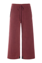 Load image into Gallery viewer, Fleece pants with flair legs in mid-calf length. The pants have pockets in the sides and ties in the front.

Guaranteed to become a favourite in your wardrobe, these pants are extremely versatile and can be styled for multiple occasions. Use them with a sweater and boots for a comfortable and relaxed look, or style them with heels and stockings for festive occasions. They can also be worn as casual wear at home, on lazy Sunday mornings.