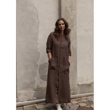 Load image into Gallery viewer, A long jacket designed with a straight, relaxed silhouette and a clean, functional feel. Buttoned through the front for versatile wear and an easy, timeless look.
The sleeves can be adjusted with grosgrain band and button details, while side pockets and a waistband add comfort and flexibility. Wear it open as a light jacket, layered over a bikini at the beach, or buttoned up as a dress - a style with many possibilities.

- 100% EU production
- 100% pure natural hemp
- OEKO-TEX® STANDARD 100 cert. no. 2176-3
