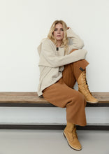 Load image into Gallery viewer, A relaxed hoodie in HSCPH’s signature fleece, designed with an oversized silhouette and soft drape. The V-neck and signature grosgrain details add a refined balance to the relaxed shape, creating a look that feels both casual and considered. Warm, lightweight and uncomplicated to wear, it is designed for comfort without feeling heavy. A calm everyday piece with versatile styling possibilities.
Style it with matching fleece trousers for a relaxed tonal look or pair it with a long jersey skirt for a more refi