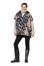 Load image into Gallery viewer, A padded cape with a print and thermal filling, perfect for cool autumn days.

This padded cape with a print has a generous silhouette and a thermal filling that offers warmth while keeping a supple, versatile feel. Push buttons along the side seams allow for an adjustable fit, while a fixed hood and fleece-lined welt pockets with decorative stitching add both function and detail. A two-way YKK zipper at the front completes the design. Perfect for cool autumn days.

