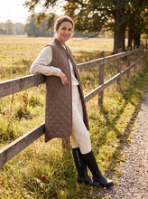 Load image into Gallery viewer, This long, A-line quilted vest with a side slit features soft padding for lightweight warmth. Press-button closures and a slightly elongated back hem give it a balanced, contemporary shape. A ribbed collar, welt pockets, and a two-way YKK zipper at the front complete the design. A versatile piece made for transitional weather, ready to wear on its own or layered under your raincoat.

Materials:

Composition: 100% Polyester
Lining: 100% Polyester
Padding: 100% Polyester