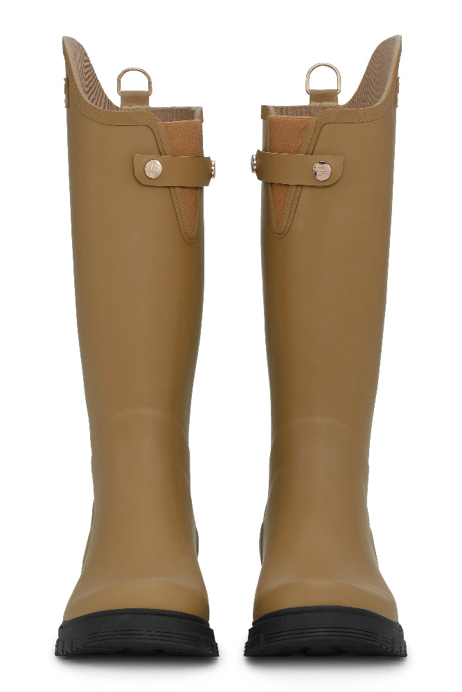 all asymmetric knee length wellingtons. A combination of style and functionality for rainy days. Featuring a decorative D-ring at center back and logo on the shaft. Elastic for easy access and a strap with logo gold buttons for decorations. The rubber sole ensures excellent traction on wet surfaces.