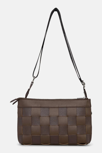 Small crossbody bag in a woven fabric with guitar strap.