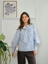 Load image into Gallery viewer, Feminine shirt in a striped quality. The shirt has a big bow at the collar and cute puff sleeve details at the shoulder.&nbsp;

The Model is 176 cm and is wearing a size 36.
