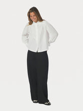 Load image into Gallery viewer, Long-sleeved shirt with a high neck and a loose fit. The shirt has buttons at the front and comes in a poplin quality. The model is wearing size 36.