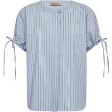 Load image into Gallery viewer, The Madison SS Shirt brings a fresh, feminine twist to classic shirting. Crafted in a soft Kentucky blue stripe, it features a relaxed silhouette with delicate tie details at the sleeves, adding subtle movement and a playful finish.
Size &amp; Fit
• Relaxed fit
• Straight silhouette
• Hip length
• Short sleeves with adjustable ties
Details
• Round neckline
• Vertical stripe pattern
• Sleeve tie detailing