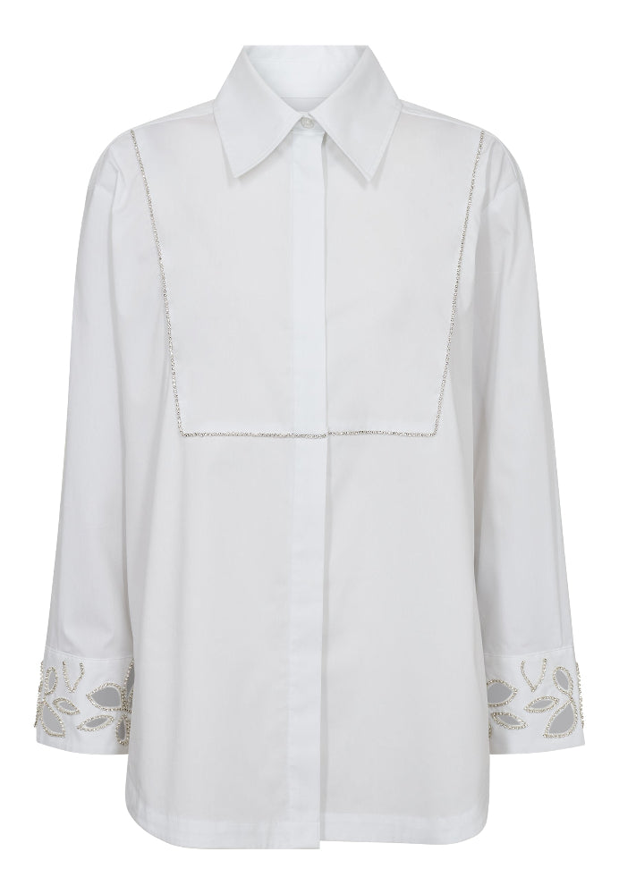 Dahlia Long Shirt is a contemporary update to the crisp white shirt. Designed with a decorative front flap detail and delicate embellishment along the cuffs and shoulders, it blends tailoring tradition with modern femininity.
The slightly A-line silhouette ensures an effortless fit, while the clean lines and hidden placket add a minimalist finish.
Size & Fit
• Regular fit
• Slightly A-line shape
• Hip length
• Long sleeves
Details
• Classic cotton shirt with elevated details
