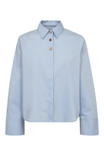 Load image into Gallery viewer, A classic reimagined with a refined twist. The Nyla Shirt is crafted from crisp cotton poplin in a cropped, slightly boxy silhouette with a sharp collar and wide cuffs. The standout detail? Contrasting decorative buttons at the neck - subtle yet striking.
Size &amp; Fit
• Cropped fit.
• Boxy silhouette.
• Full-length sleeves with wide cuffs.
• True to size.
Details
• Decorative contrast buttons at neckline.
• Hidden button placket.
• Clean finish hem.