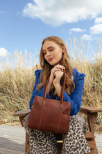 Load image into Gallery viewer, Nellie Small is a stylish and versatile bag in a timeless design.
• Handcrafted
• Back zip pocket
• Two zippered main compartments
• Adjustable, removable crossover strap
Made in our Grain Leather Quality - a naturally grained cow leather that is drum-dyed to preserve the original texture and supple feel. Each piece is cut by hand and polished with wax, to achieve a distinctive and soft finish. This Process preserves the beauty of the raw leather, with natural variations enhancing the unique characteristics