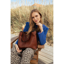 Load image into Gallery viewer, Naya Big is a chic and practical bag designed for everyday use.
• Handcrafted
• Two separate main compartments with a zippered pocket in the center
• Adjustable shoulder strap
• Button closure
Made in our Grain Leather Quality - a naturally grained cow leather that is drum-dyed to preserve the original texture and supple feel. Each piece is cut by hand and polished with wax, to achieve a distinctive and soft finish. 