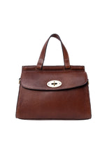 Load image into Gallery viewer, Saya Medium is a cool crossover bag with a modern shape.
• Handcrafted
• Feminine gold buckle closure
• Adjustable, removable crossover strap
• One handle on the top
• Spacious main compartment
Made in our Grain Leather Quality - a naturally grained cow leather that is drum-dyed to preserve the original texture and supple feel. Each piece is cut by hand and polished with wax, to achieve a distinctive and soft finish. This Process preserves the beauty of the raw leather, with natural variations enhancing the