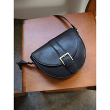 Load image into Gallery viewer, Usi is a simple and elegant crossover suitable for any occasion.
• Handcrafted
• Adjustable strap
• Button closure
• Gold buckle detail
The Ohara Leather Quality is a semi-naked leather, characterized by its rich, natural expression created through a rare process of handcrafted finish. It is made from vegetable-tanned leather, where the leather only receives a single layer of color before being finely polished once the bag is complete. This creates an authentic vintage finish, where each bag carries its own
